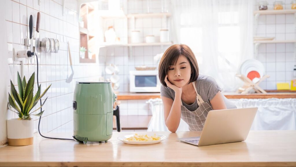 キッチンにいるパソコンを見ている女性